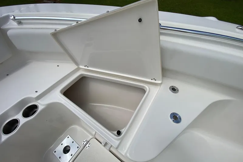 Slide: The Image of 2023 Key West 239 FS boat storage compartment with open lid and cup holders. - 93