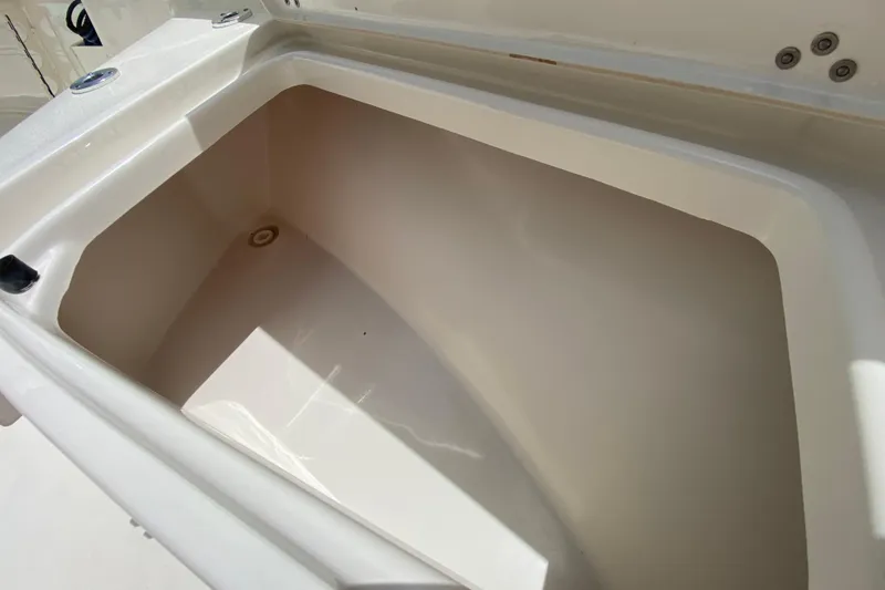 Slide: The Image of 2023 Key West 239 FS boat storage compartment, open and empty, with sunlight illuminating interior. - 96