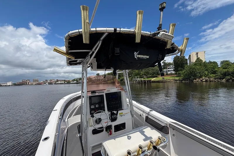 Slide: The Image of 2006 Seaswirl Striper 2601 boat on calm water, featuring a Fishmaster T-top. - 10