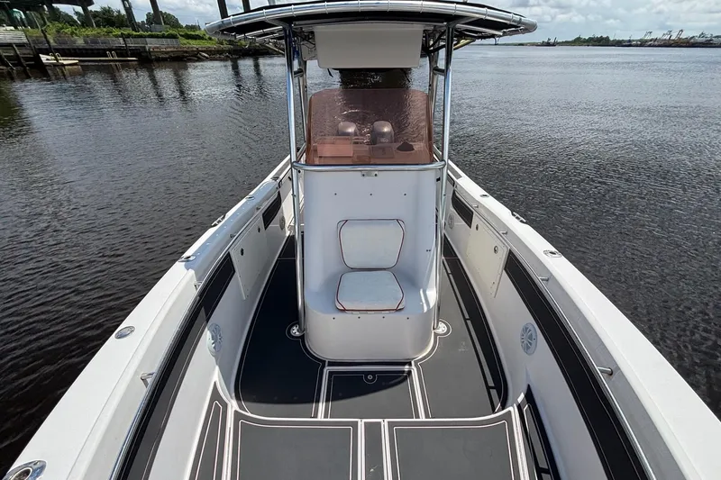 Slide: The Image of 2006 Seaswirl Striper 2601 boat on calm water, featuring spacious deck and seating. - 13