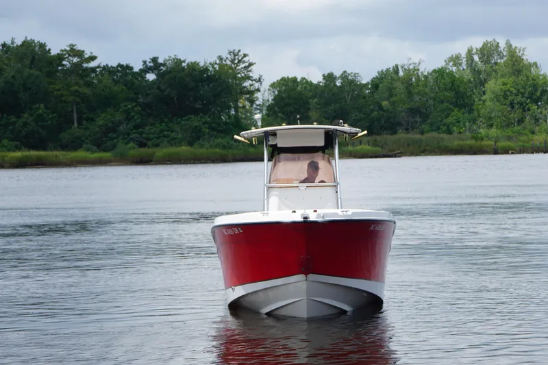 Slide: The Image of 2006 Seaswirl Striper 2601 boat on calm water, surrounded by lush greenery. - 3