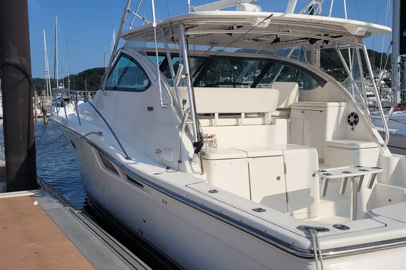 Slide: The Image of 2006 Tiara Yachts 4200 Open docked at marina, showcasing sleek design and spacious deck. - 10