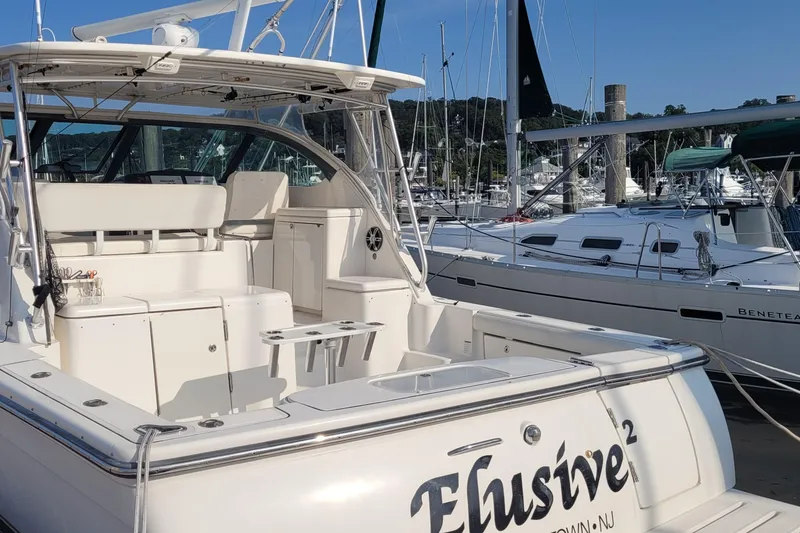 Slide: The Image of 2006 Tiara Yachts 4200 Open docked at marina, featuring spacious deck and seating area. - 12