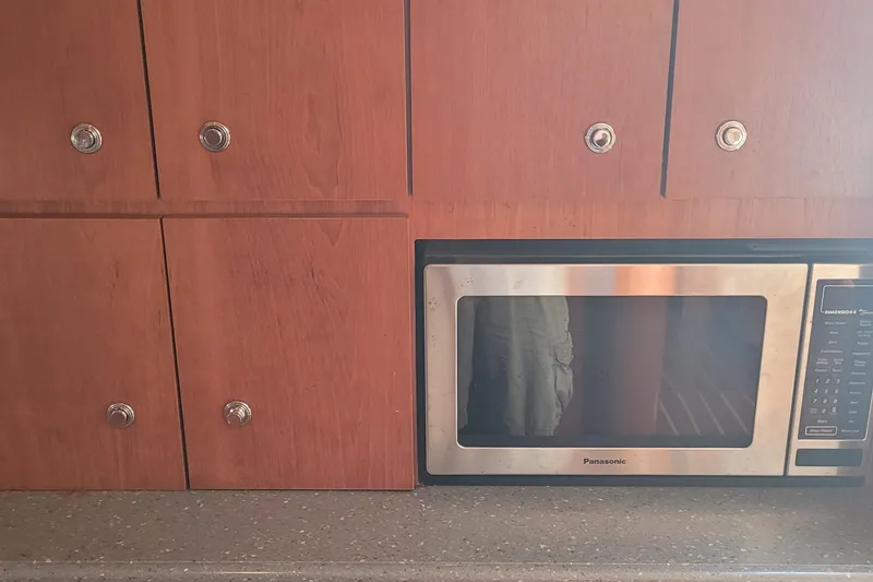 Slide: The Image of Wooden cabinets and a Panasonic microwave in a 2006 Tiara Yachts 4200 Open. - 29