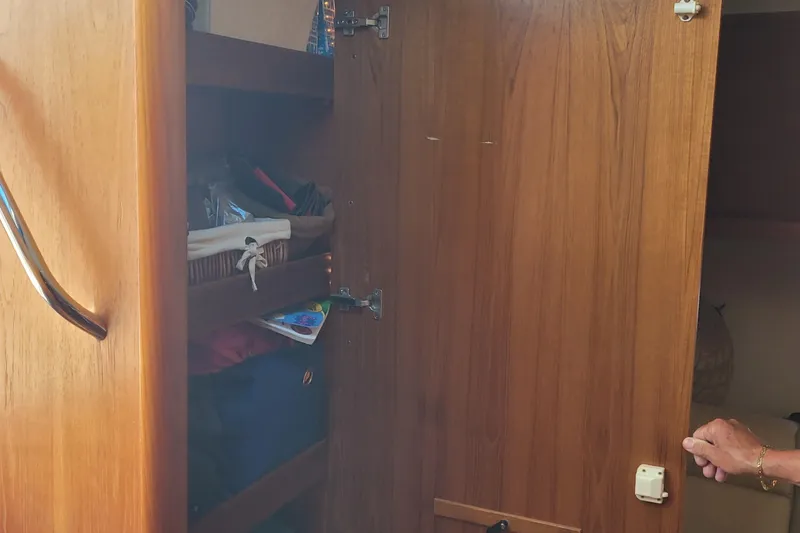 Slide: The Image of Open wooden cabinet on 2006 Tiara Yachts 4200 Open, revealing storage shelves. - 34