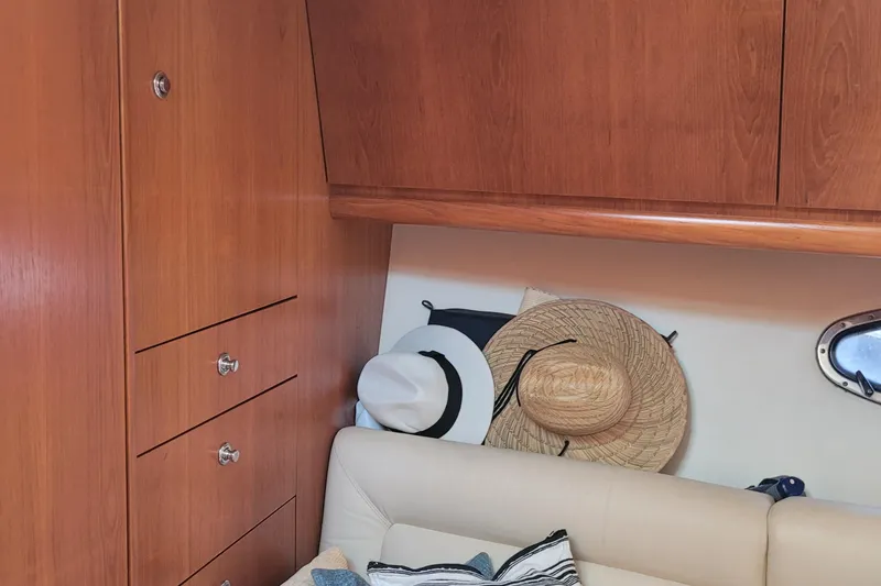 Slide: The Image of Interior of 2006 Tiara Yachts 4200 Open with wooden cabinets and hats on a sofa. - 35