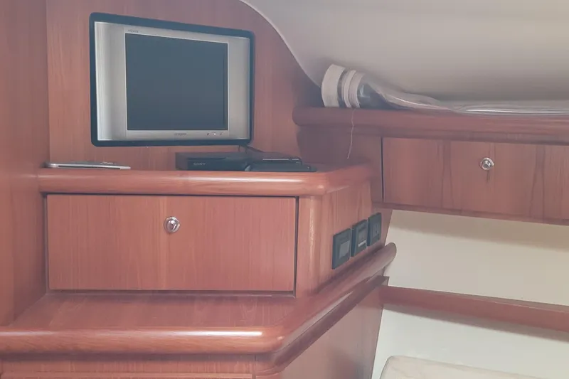 Slide: The Image of 2006 Tiara Yachts 4200 Open cabin interior with TV and wooden cabinetry. - 37