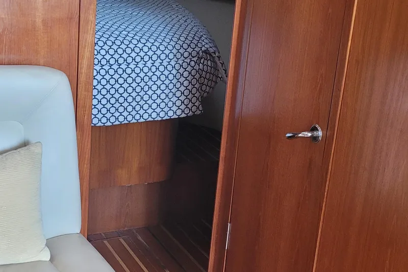 Slide: The Image of Interior of 2006 Tiara Yachts 4200 Open, featuring wood paneling and patterned bedding. - 49