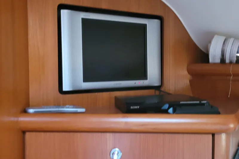 Slide: The Image of Entertainment setup inside 2006 Tiara Yachts 4200 Open, featuring a TV and media player. - 51