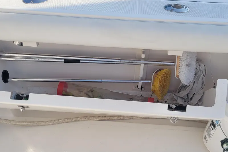 Slide: The Image of Storage compartment on a 2006 Tiara Yachts 4200 Open, containing cleaning brushes and tools. - 59