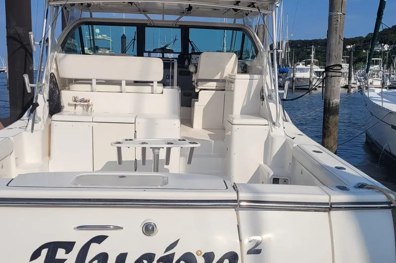 Slide: The Image of 2006 Tiara Yachts 4200 Open docked at marina, showcasing spacious deck and seating area. - 8