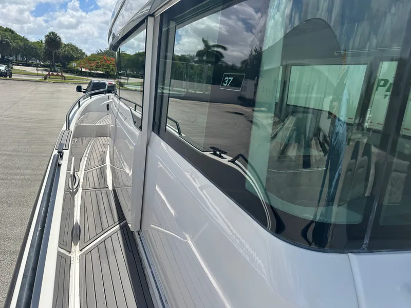 Slide: The Image of 2020 Axopar 37 XC CROSS CABIN boat side view with sleek design and reflective windows. - 24