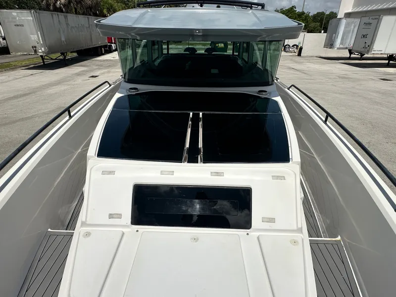 Slide: The Image of 2020 Axopar 37 XC CROSS CABIN boat, docked, showcasing sleek design and spacious deck. - 26