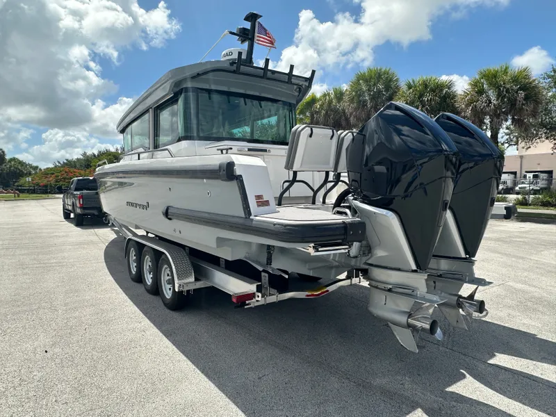 Slide: The Image of 2020 Axopar 37 XC CROSS CABIN on trailer, dual outboard engines, sunny day, palm trees. - 3