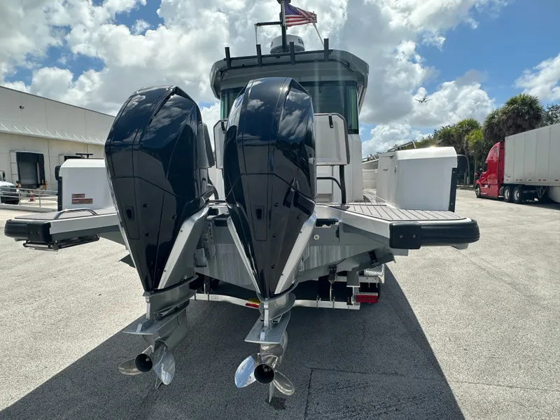 Slide: The Image of 2020 Axopar 37 XC CROSS CABIN with dual outboard engines, docked under a cloudy sky. - 5