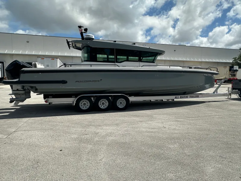 Slide: The Image of 2020 Axopar 37 XC CROSS CABIN boat on trailer, parked outdoors under cloudy sky. - 8