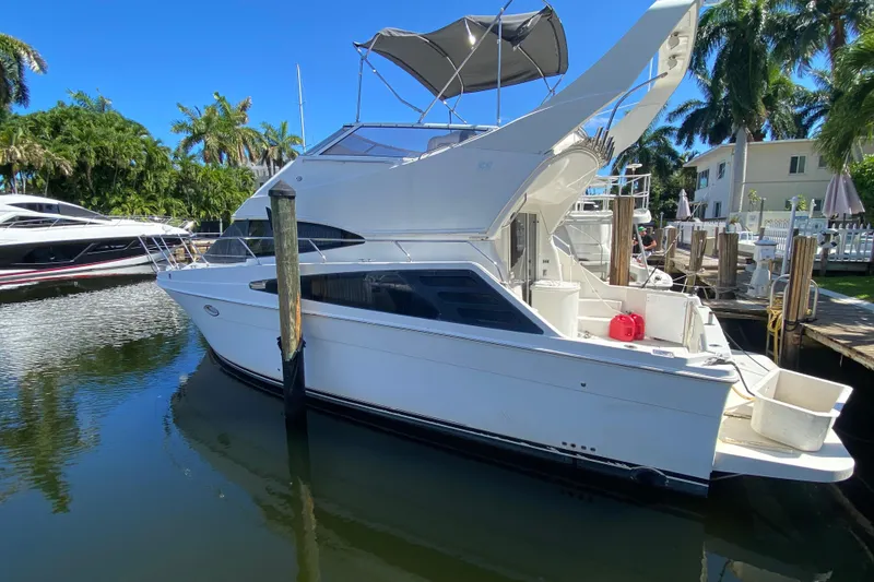 Slide: The Image of 2006 Carver 33 Super Sport yacht docked in a sunny marina setting. - 15