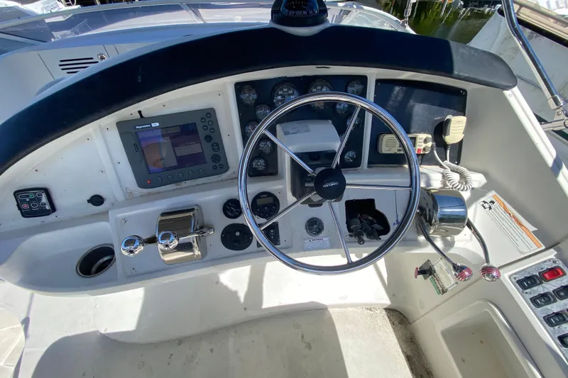 Slide: The Image of 2006 Carver 33 Super Sport helm with steering wheel, controls, and navigation equipment. - 22