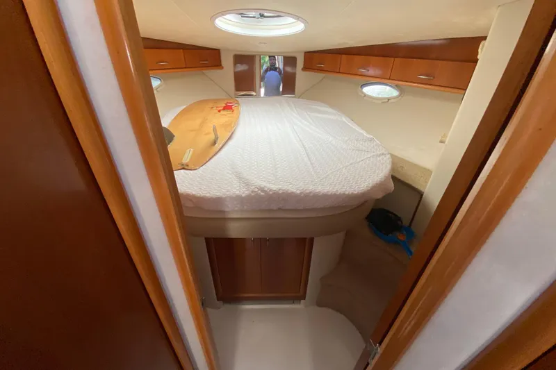 Slide: The Image of 2006 Carver 33 Super Sport cabin interior with bed and wooden cabinetry. - 27