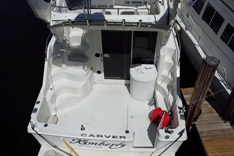 Slide: The Image of 2006 Carver 33 Super Sport yacht docked, featuring spacious deck and seating area. - 33