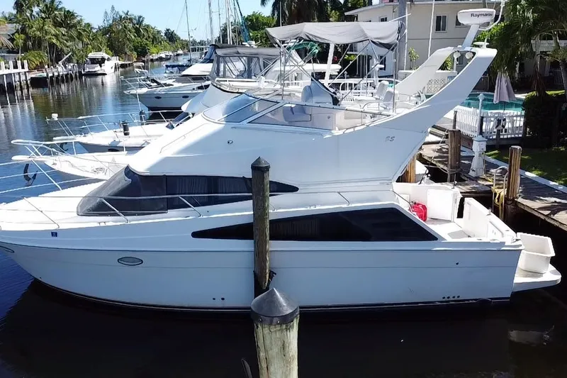 Slide: The Image of 2006 Carver 33 Super Sport yacht docked in a serene marina setting. - 5