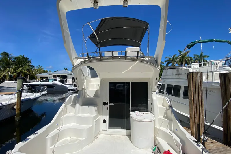 Slide: The Image of 2006 Carver 33 Super Sport yacht docked at marina, featuring upper deck and sleek design. - 18