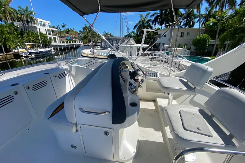 Slide: The Image of 2006 Carver 33 Super Sport yacht cockpit with helm and seating, docked in a sunny marina. - 20