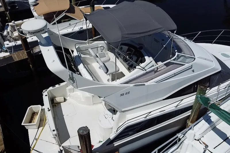 Slide: The Image of 2006 Carver 33 Super Sport yacht docked at marina, featuring spacious deck and canopy. - 30