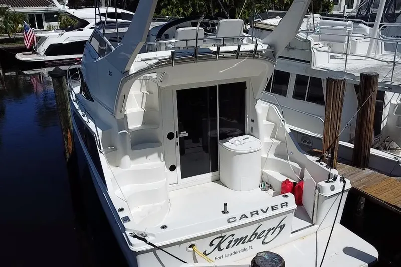 Slide: The Image of 2006 Carver 33 Super Sport yacht docked, rear view with name "Kimberly" visible. - 35