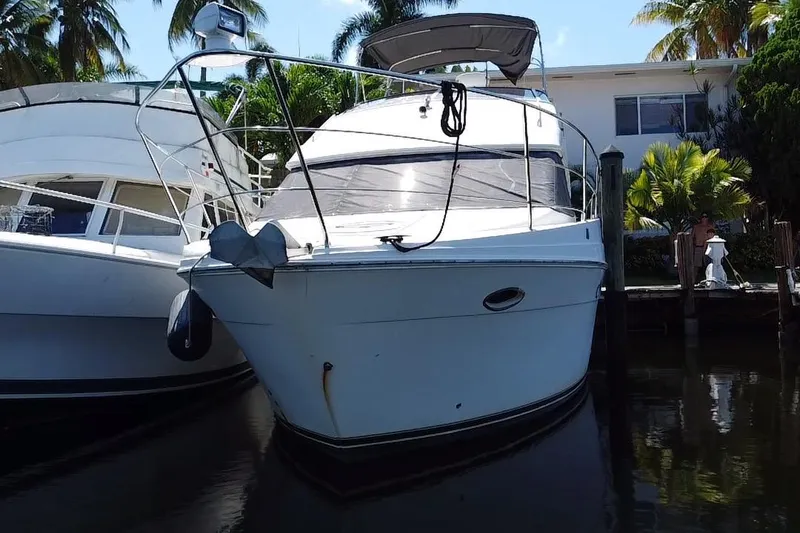 Slide: The Image of 2006 Carver 33 Super Sport yacht docked near palm trees. - 7