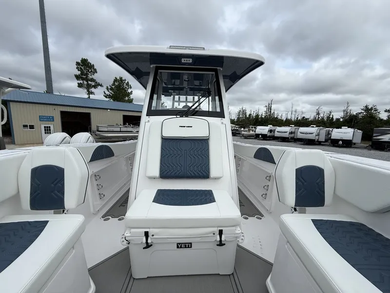 Slide: The Image of 2026 Twin Vee GFX2 260 boat interior with blue and white seating, overcast sky. - 15