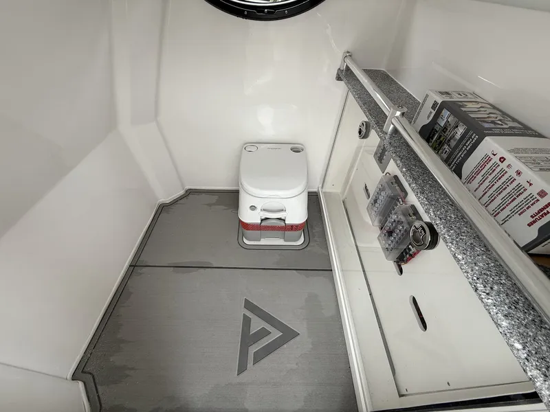 Slide: The Image of Interior of 2026 Twin Vee GFX2 260 boat with compact toilet and storage area. - 7