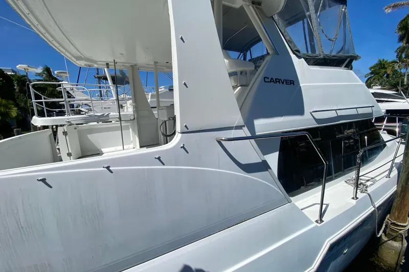 Slide: The Image of 2003 Carver 356 Motor Yacht docked, showcasing sleek white exterior and spacious deck. - 13