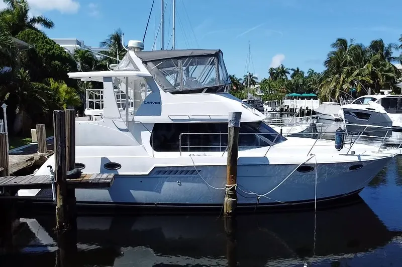 Slide: The Image of 2003 Carver 356 Motor Yacht docked in a sunny marina with palm trees. - 3
