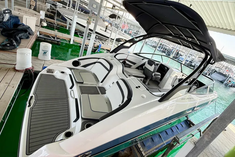 Slide: The Image of 2018 Yamaha Boats 242 Limited S E-Series docked, showcasing sleek design and spacious interior. - 11