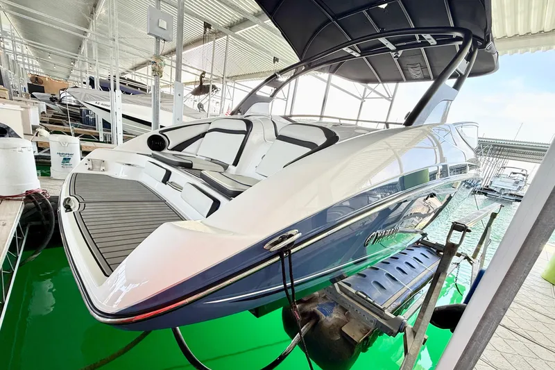 Slide: The Image of 2018 Yamaha Boats 242 Limited S E-Series in marina, sleek design, elevated on lift. - 13