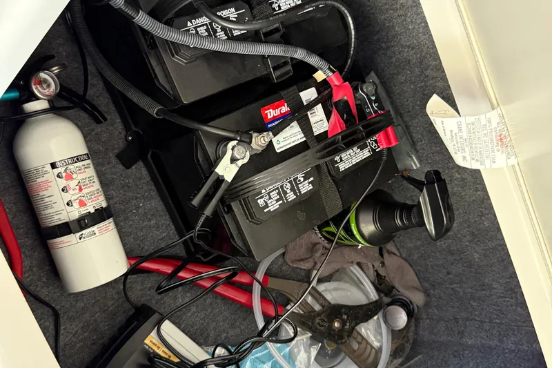 Slide: The Image of Storage compartment of a 2018 Yamaha Boats 242 Limited S E-Series with battery and fire extinguisher. - 23