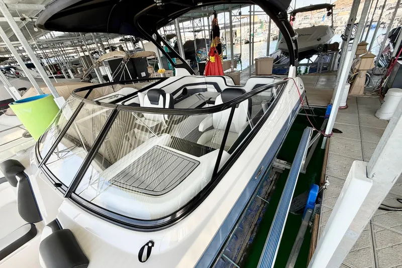 Slide: The Image of 2018 Yamaha Boats 242 Limited S E-Series in marina, showcasing sleek design and seating. - 7