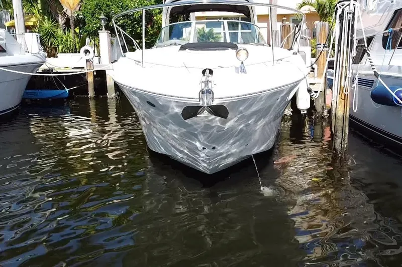 Slide: The Image of 2012 Sea Ray 330 Sundancer docked in marina, reflecting on calm water. - 2