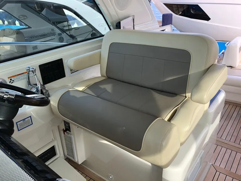Slide: The Image of Captain's seat on 2012 Sea Ray 450 Sundancer yacht, featuring beige and gray upholstery. - 10