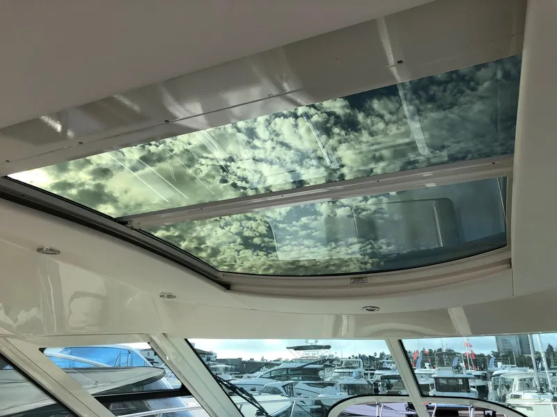 Slide: The Image of Sunroof view from 2012 Sea Ray 450 Sundancer yacht, showcasing sky and marina. - 12