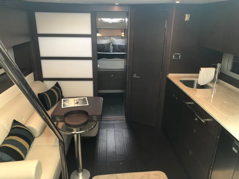 Slide: The Image of Luxurious interior of 2012 Sea Ray 450 Sundancer yacht with modern furnishings and kitchenette. - 15