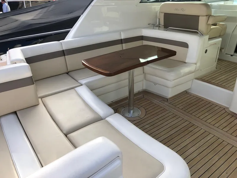 Slide: The Image of 2012 Sea Ray 450 Sundancer yacht interior with beige seating and wooden table. - 7