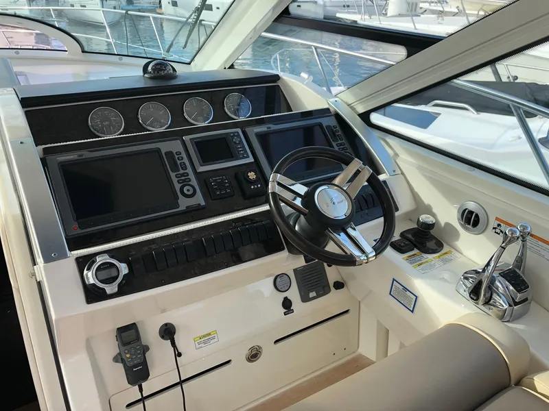 Slide: The Image of 2012 Sea Ray 450 Sundancer helm with modern controls and navigation displays. - 9