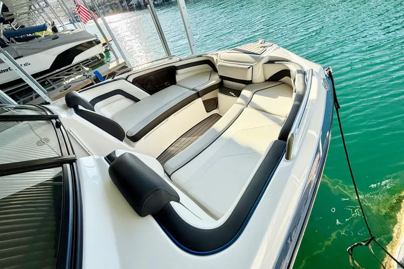 Slide: The Image of 2018 Yamaha Boats 242 Limited S E-Series interior with sleek seating on calm water. - 12