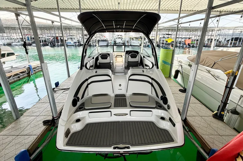 Slide: The Image of 2018 Yamaha Boats 242 Limited S E-Series docked in a marina, showcasing sleek design and spacious interior. - 32