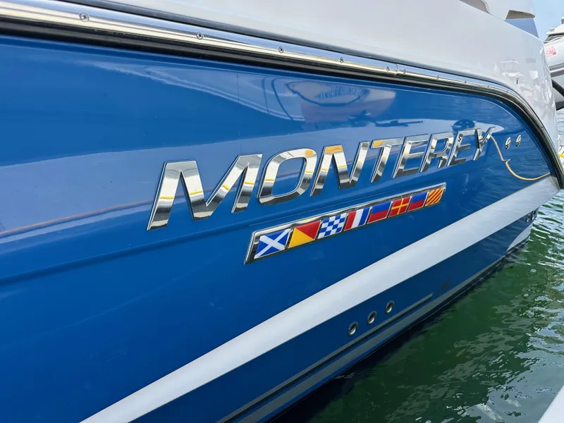 Slide: The Image of 2020 Monterey 355 Sport Yacht with nautical flags on blue hull. - 13
