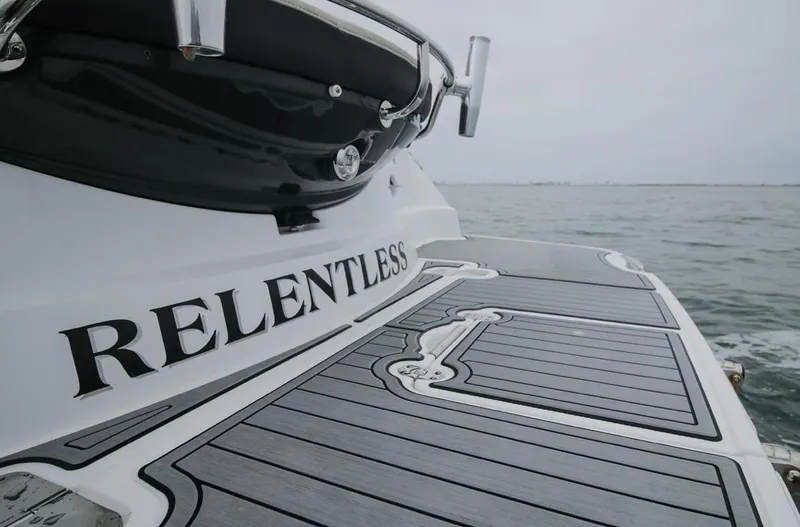 Slide: The Image of 2020 Monterey 355 Sport Yacht, rear view with "Relentless" name, on calm water. - 18