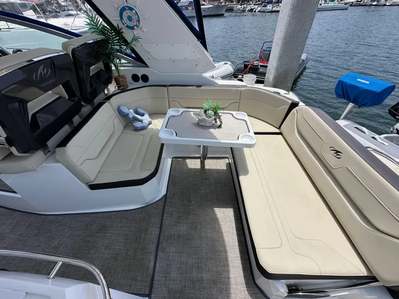 Slide: The Image of 2020 Monterey 355 Sport Yacht interior with beige seating and table, docked at marina. - 25