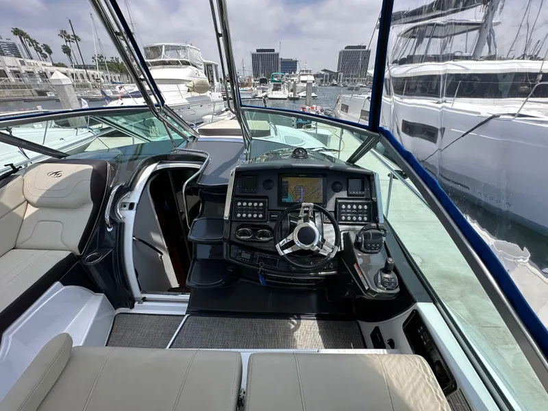 Slide: The Image of 2020 Monterey 355 Sport Yacht cockpit with modern controls, docked in a marina. - 33